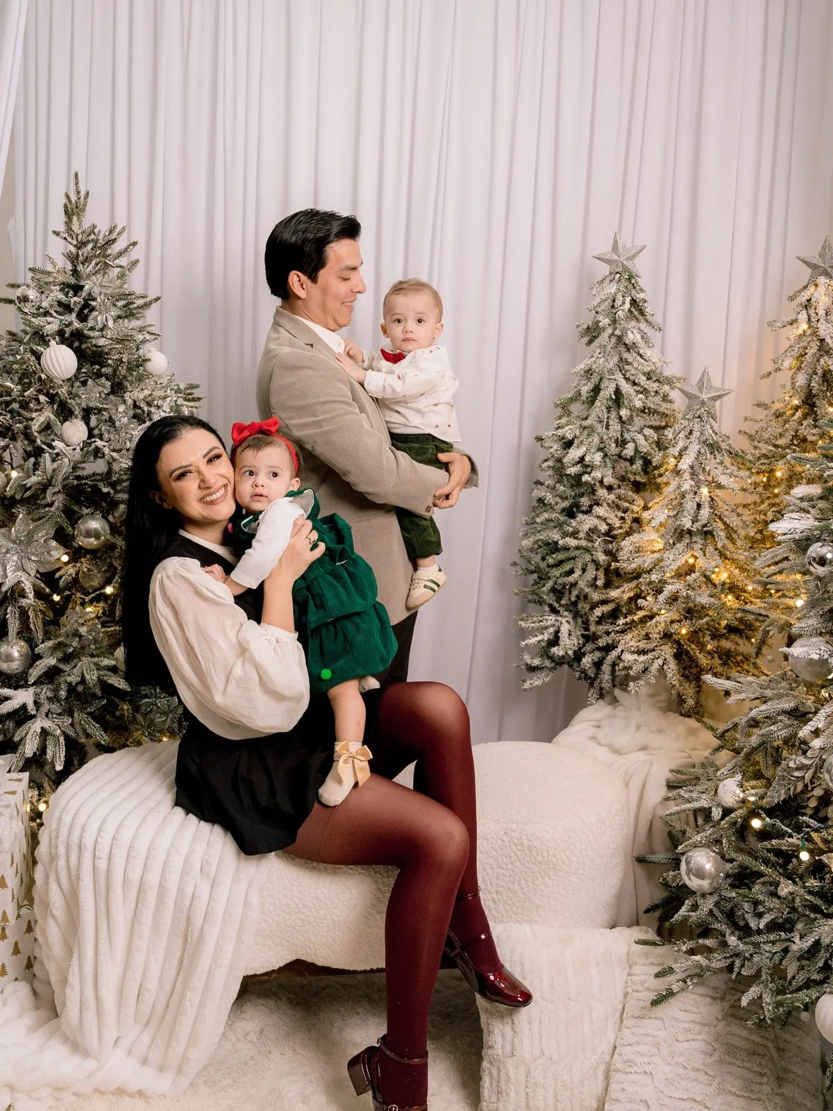 Familia con un bebé entre pinos nevados